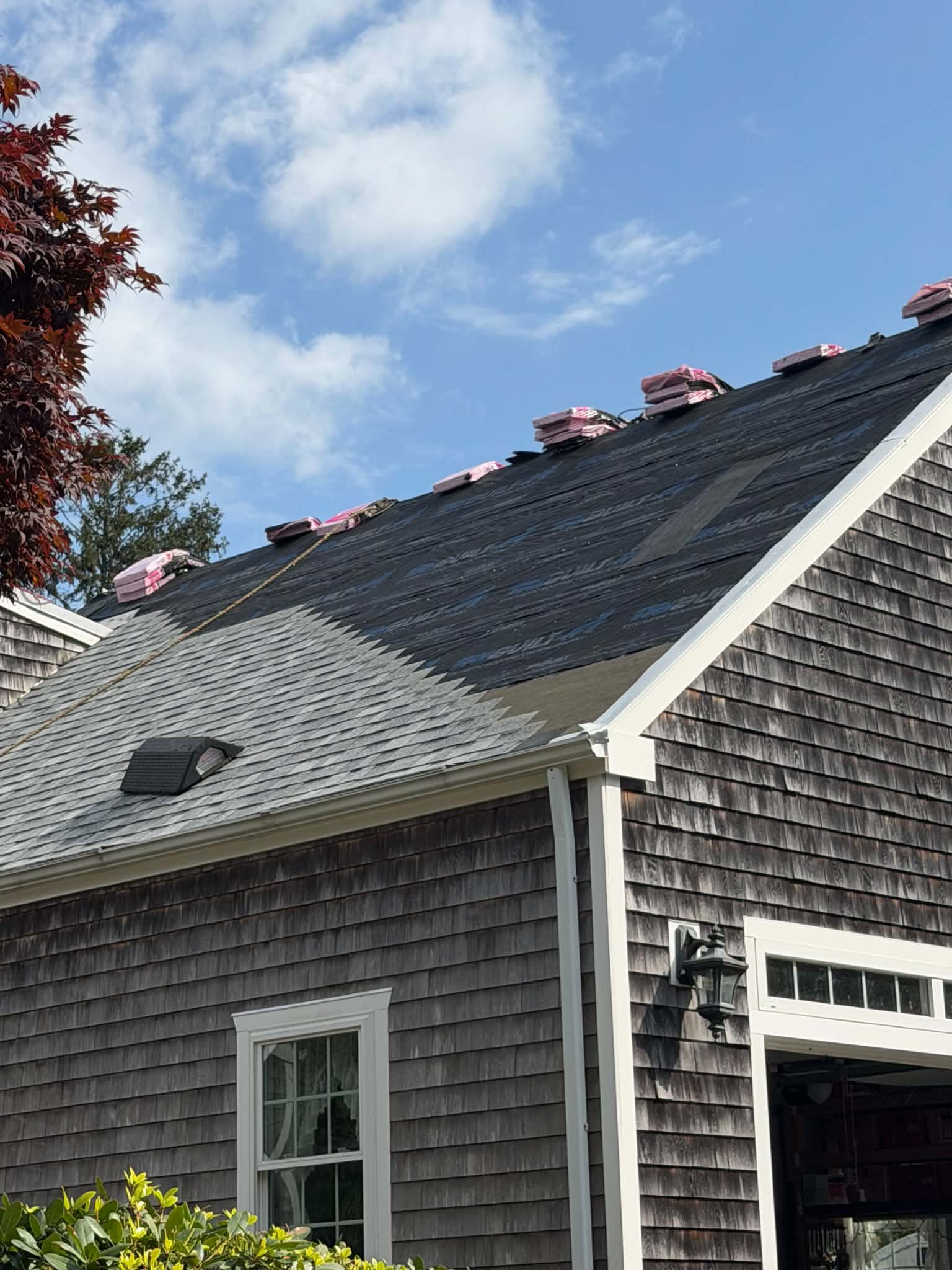 Services Roof replacement in progress with new underlayment and shingle bundles